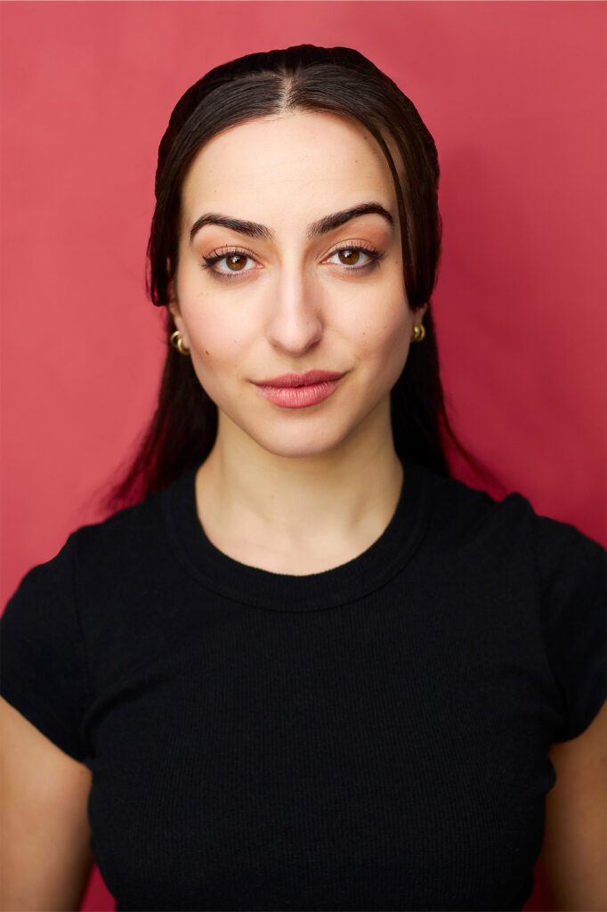 Black hair actress, strong facial features, with red backdrop, black shirt, headshot, nyc photographer