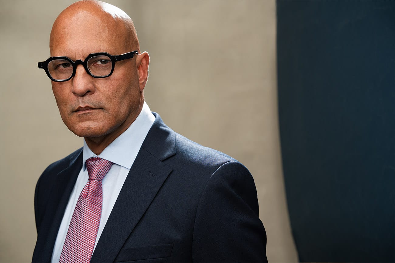 Stern gentleman with dark black thick rimmed glasses, in a suit staring hard at the camera, NYC Headshot Photographer