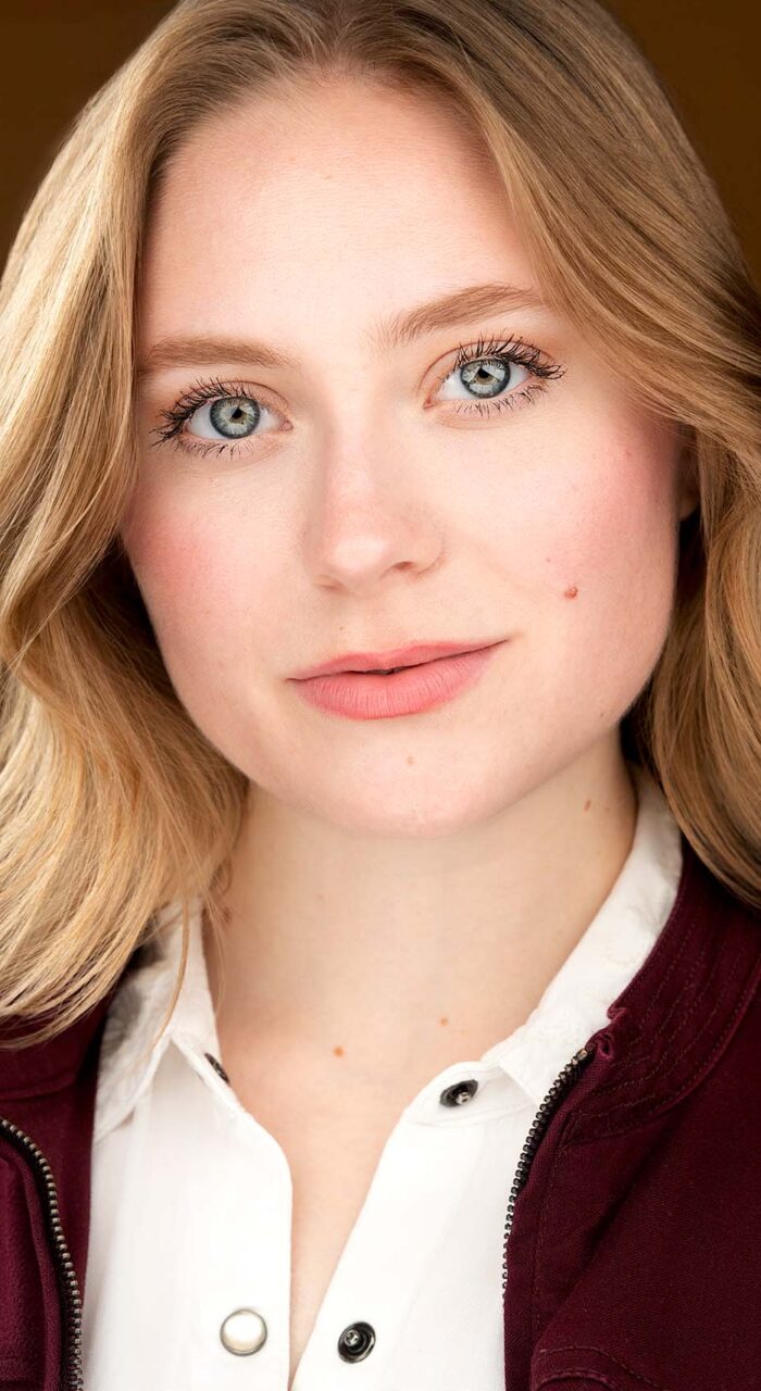 Actor headshot of Emily Paruk against a warm brown background