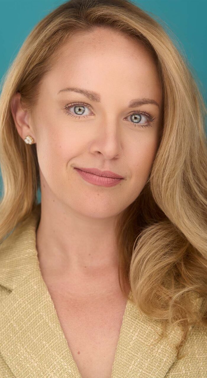 Professional headshot of Leanne Smith against a teal background